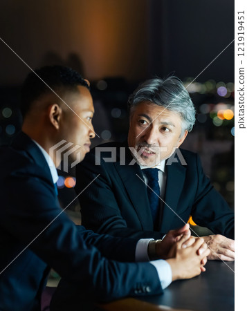 跨國商人晚上在辦公室看著螢幕開會 121919451