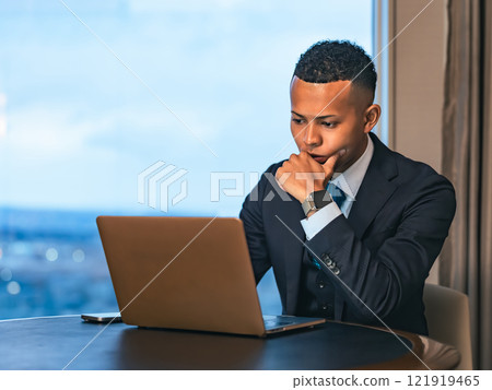 Businessman working on a laptop in a high-rise office 121919465
