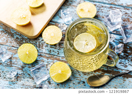 Fresh iced lemon tea soda in glass on a grunge wood table. Inside the glass are fresh lemon slices. Soft drink for hot weather. Fresh iced lemon tea soda in glass on a grunge wood table. Inside the glass are fresh lemon slices. Soft drink for hot weather. 121919867