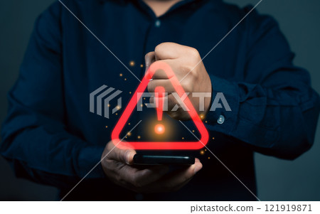 Man using smartphone with warning sign.Notification error and virus detection spyware. Emergency warning alert alarm on smartphone. Data network protection. Virus alarm. Man using smartphone with warning sign.Notification error and virus detection spyware. Emergency warning alert alarm on smartphone. Data network protection. Virus alarm. 121919871