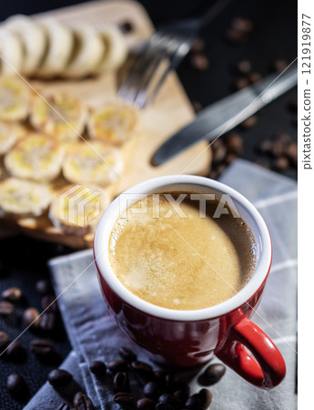 Hot of black coffee or Americano coffee with white bread and banana on top. 121919877