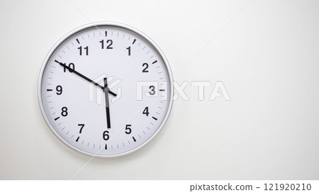 Minimalist White Clock with Silver Frame Striking 17.50/05.50 on White Background. Perfect for Time Management and Corporate Campaigns Minimalist White Clock with Silver Frame Striking 17.50/05.50 on White Background. Perfect for Time Management and Corporate Campaigns 121920210