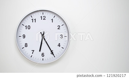 Minimalist White Clock with Silver Frame Striking 18.25/06.25 on White Background. Perfect for Time Management and Corporate Campaigns Minimalist White Clock with Silver Frame Striking 18.25/06.25 on White Background. Perfect for Time Management and Corporate Campaigns 121920217