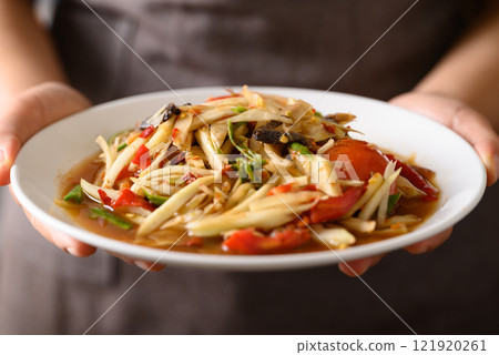 Spicy papaya salad (Som Tum) with hand, Local Thai food 121920261