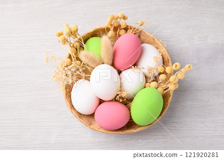 White easter eggs with bunny rabbit ears and colorful easter eggs in basket on white background 121920281