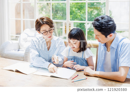 Parents looking stern at their elementary school daughter studying Parents looking stern at their elementary school daughter studying 121920380