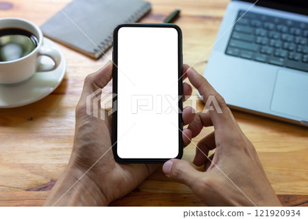 man hand using smartphone In the office Screen blank with clipping path ,Top view mockup image of male holding mobile phone with empty white screen 121920934