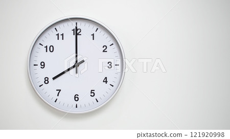 Minimalist White Clock with Silver Frame Striking 20.00/08.00 on White Background. Perfect for Time Management and Corporate Campaigns Minimalist White Clock with Silver Frame Striking 20.00/08.00 on White Background. Perfect for Time Management and Corporate Campaigns 121920998