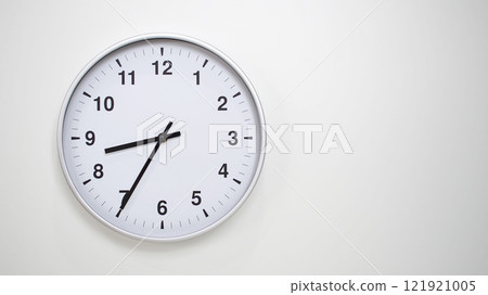 Minimalist White Clock with Silver Frame Striking 20.35/08.35 on White Background. Perfect for Time Management and Corporate Campaigns Minimalist White Clock with Silver Frame Striking 20.35/08.35 on White Background. Perfect for Time Management and Corporate Campaigns 121921005