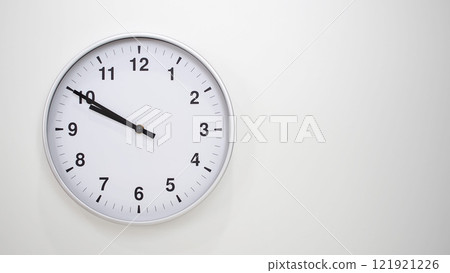 Minimalist White Clock with Silver Frame Striking 21.50/09.50 on White Background. Perfect for Time Management and Corporate Campaigns Minimalist White Clock with Silver Frame Striking 21.50/09.50 on White Background. Perfect for Time Management and Corporate Campaigns 121921226