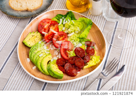 Lettuce and tomatoes served with chorizo and avocado 121921874