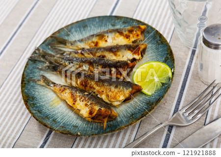 Golden fried sardines with slice of lemon for healthy dining 121921888