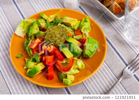 Plate contains portion of salad from fresh vegetables and pesto sauce. Plate contains portion of salad from fresh vegetables and pesto sauce. 121921931