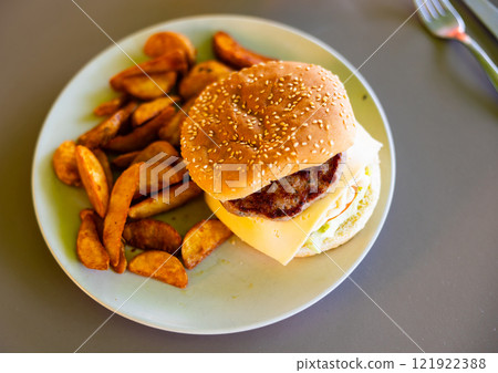 Delicious cheeseburger with beef patty and cheese on plate, with french fries 121922388