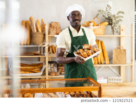Smiling baker offers to buy fresh hot croissants 121922521