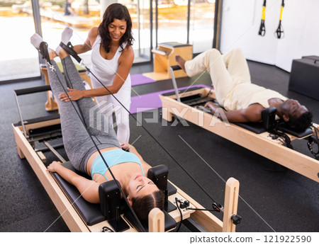 Multiracial people having pilates workout on reformers with trainer Multiracial people having pilates workout on reformers with trainer 121922590