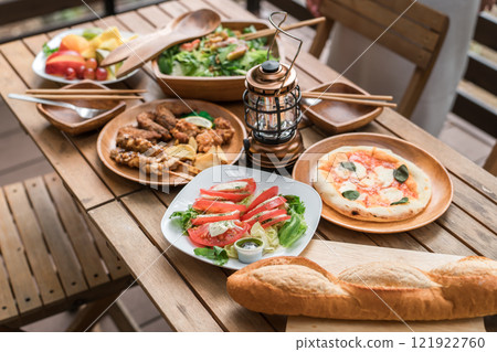 豪華西餐和適合家庭聚會和豪華露營的菜餚佈置在木甲板桌子上 121922760