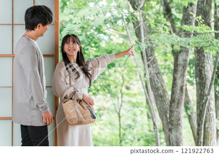 A couple staying at a hot spring inn and Japanese-style room on a domestic trip and looking at the garden view 121922763