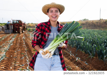 Smiling woman agriculturist with leek on vegetable plantation 121922835
