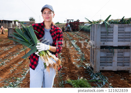 Smiling woman agriculturist with leek on vegetable plantation 121922839