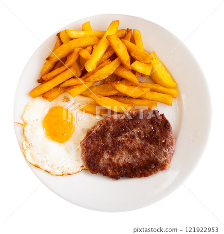 There is food for lunch on plate - two flat cutlets, French fries, fried eggs. 121922953