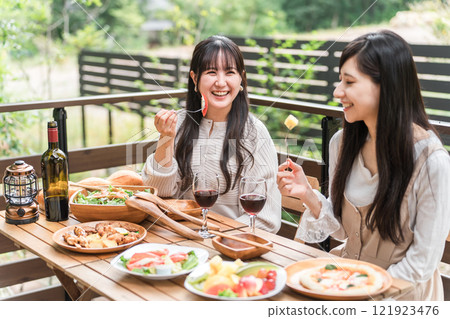 年輕女性和朋友在露臺上吃飯、燒烤、舉辦家庭聚會和豪華露營 121923476