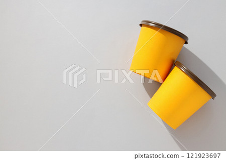 Yellow paper cups with lids on a light background 121923697