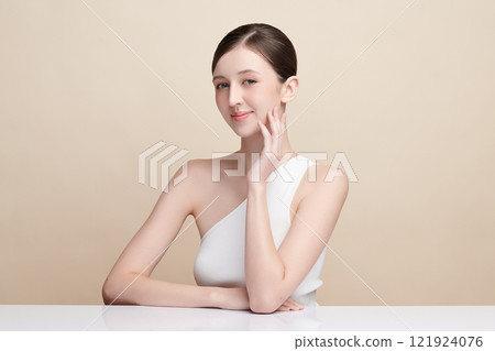 Beautiful young woman with clean fresh skin on beige background, Face care, Facial treatment, Cosmetology, beauty and spa, women portrait. 121924076