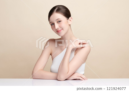 Beautiful young woman with clean fresh skin on beige background, Face care, Facial treatment, Cosmetology, beauty and spa, women portrait. 121924077