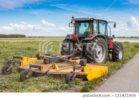 Wheel tractor with lawn mower by the road 121925909