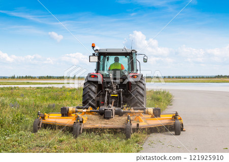 Wheel tractor with lawn mower by the road 121925910