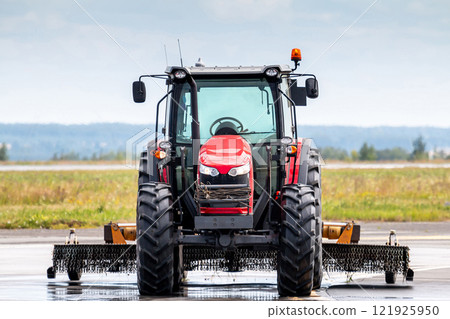 Front view of the wheel tractor with lawn mower on the road Front view of the wheel tractor with lawn mower on the road 121925950