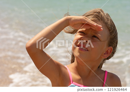 Beautiful caucasian child of 7-8 years looking at sun and covering face with hand Beautiful caucasian child of 7-8 years looking at sun and covering face with hand 121926464