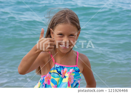 Beautiful happy caucasian child of 7-8 years with thumb up 121926466