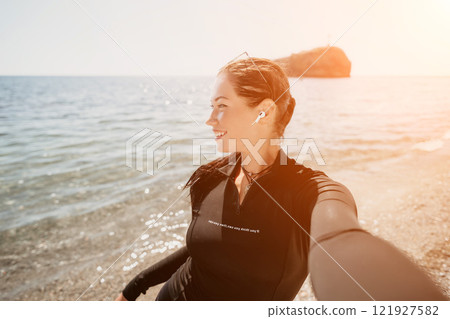 Woman Beach Selfie Sunset - Smiling woman takes a selfie on the beach at sunset. 121927582