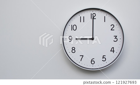 Minimalist Analog Wall Clock with White Face and Simple Black Hands Showing 21.00/09.00 - Ideal for Time Management and Modern Decor Concepts Minimalist Analog Wall Clock with White Face and Simple Black Hands Showing 21.00/09.00 - Ideal for Time Management and Modern Decor Concepts 121927693