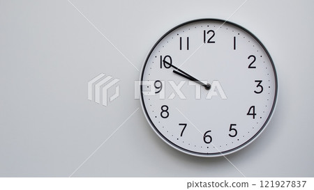 Minimalist Analog Wall Clock with White Face and Simple Black Hands Showing 21.50/09.50 - Ideal for Time Management and Modern Decor Concepts 121927837