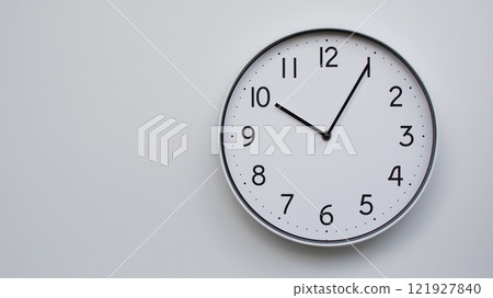 Minimalist Analog Wall Clock with White Face and Simple Black Hands Showing 10.05/22.05 - Ideal for Time Management and Modern Decor Concepts 121927840