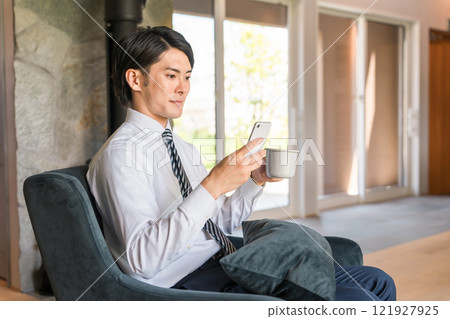 Businessman looking at smartphone/smartphone at home (news/e-books/reading/applications/schedule) Businessman looking at smartphone/smartphone at home (news/e-books/reading/applications/schedule) 121927925