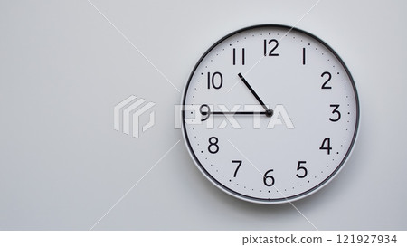 Minimalist Analog Wall Clock with White Face and Simple Black Hands Showing 10.45/22.45 - Ideal for Time Management and Modern Decor Concepts 121927934