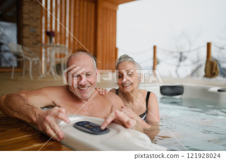 Romantic wellness getaway. Senior couple enjoying hot tub during Valentine's weekend. 121928024
