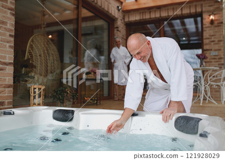 Romantic wellness getaway. Senior couple enjoying hot tub during Valentine's weekend. 121928029