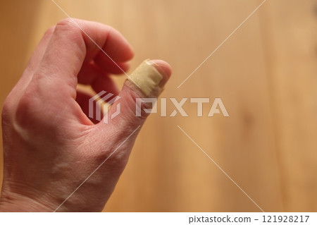 The left hand of a woman in her 40s with a bandage on it 121928217