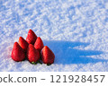 Red strawberries on snow 121928457