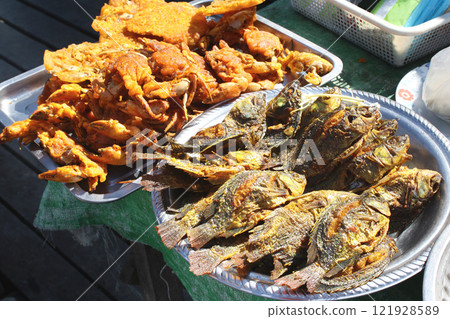 Traditional asian street food - fried fish and crabs in batter, Myanmar (Burma), Southeast Asia. Fresh sea food on street fish market 121928589