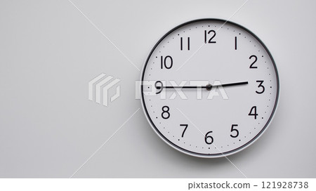 Minimalist Analog Wall Clock with White Face and Simple Black Hands Showing 14.45/02.45 - Ideal for Time Management and Modern Decor Concepts 121928738