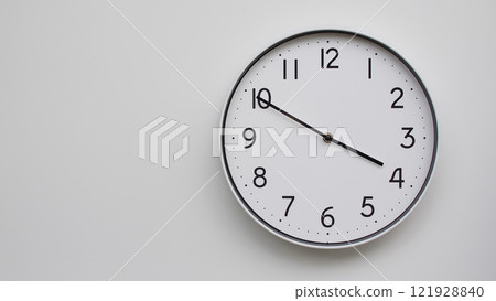 Minimalist Analog Wall Clock with White Face and Simple Black Hands Showing 15.50/03.50 - Ideal for Time Management and Modern Decor Concepts Minimalist Analog Wall Clock with White Face and Simple Black Hands Showing 15.50/03.50 - Ideal for Time Management and Modern Decor Concepts 121928840