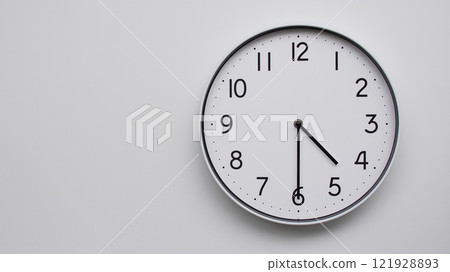 Minimalist Analog Wall Clock with White Face and Simple Black Hands Showing 16.30/04.30 - Ideal for Time Management and Modern Decor Concepts 121928893