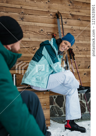 Couple preparing for cross country skiing in winter nature, putting boots on. Active valentine's weekend. 121928901
