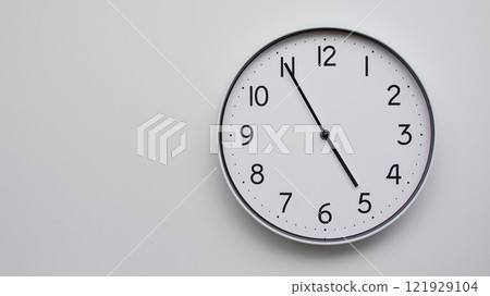 Minimalist Analog Wall Clock with White Face and Simple Black Hands Showing 16.55/04.55 - Ideal for Time Management and Modern Decor Concepts 121929104